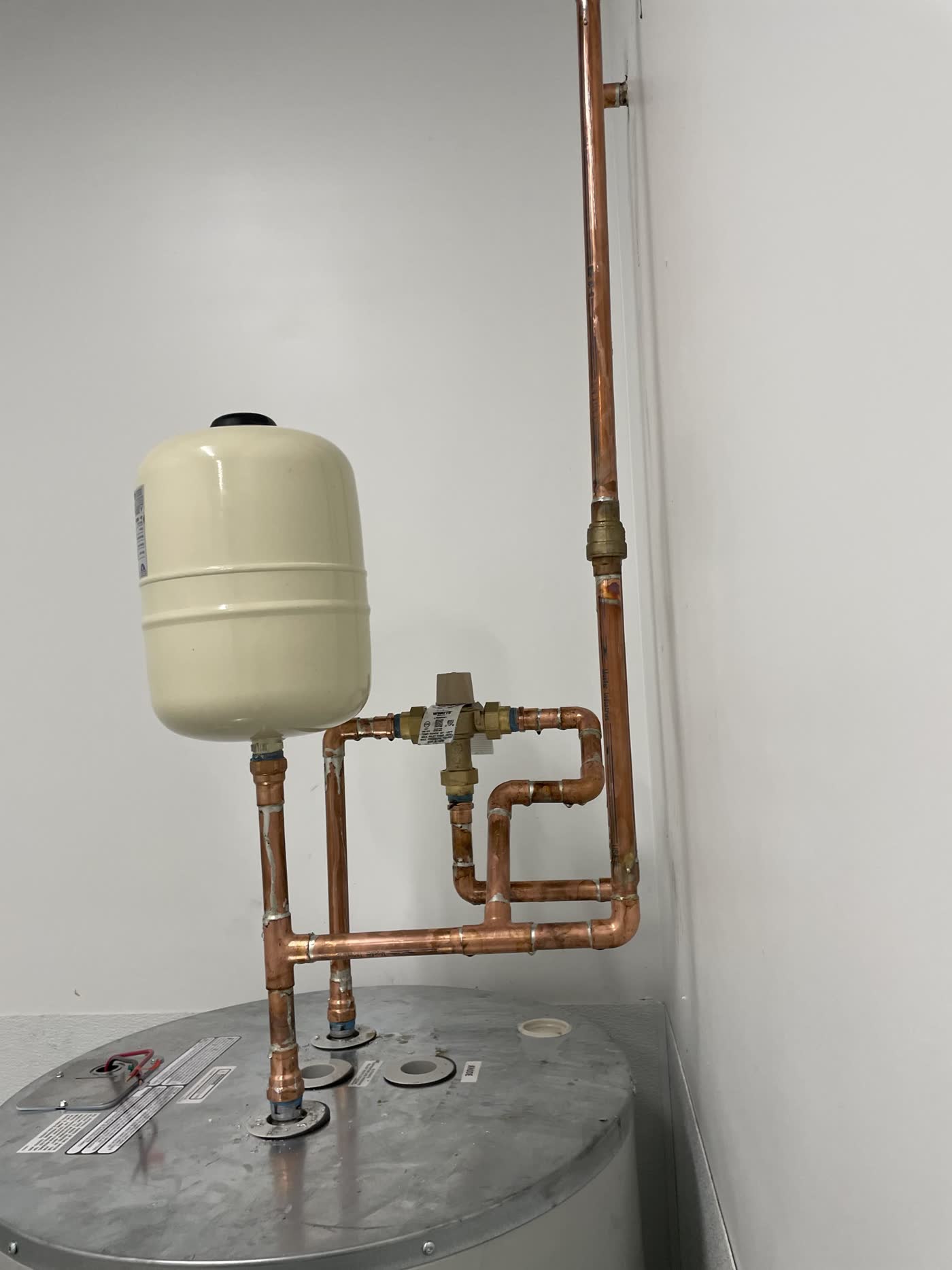New tank water heater with copper piping and an expansion tank